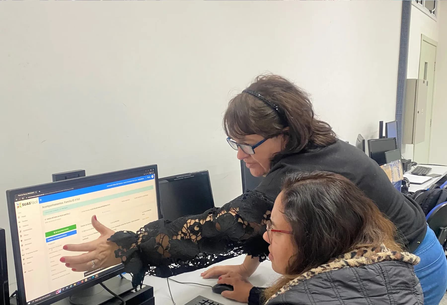 Instrutora explica uma tela da plataforma para uma profissional do SUAS